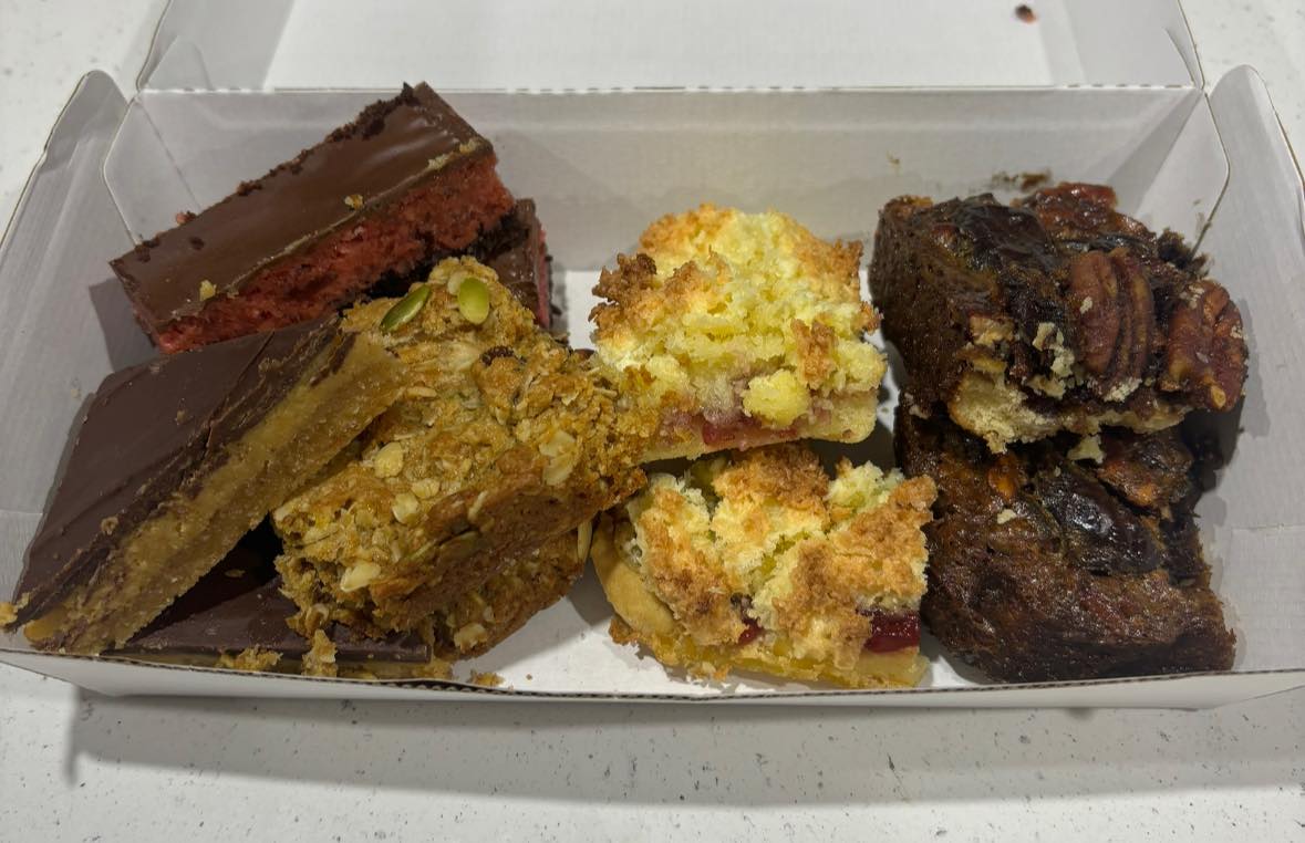 Mixed treat box with chocolate raspberry slice, anzac slice, lemon coconut slice and sticky pecan scroll
