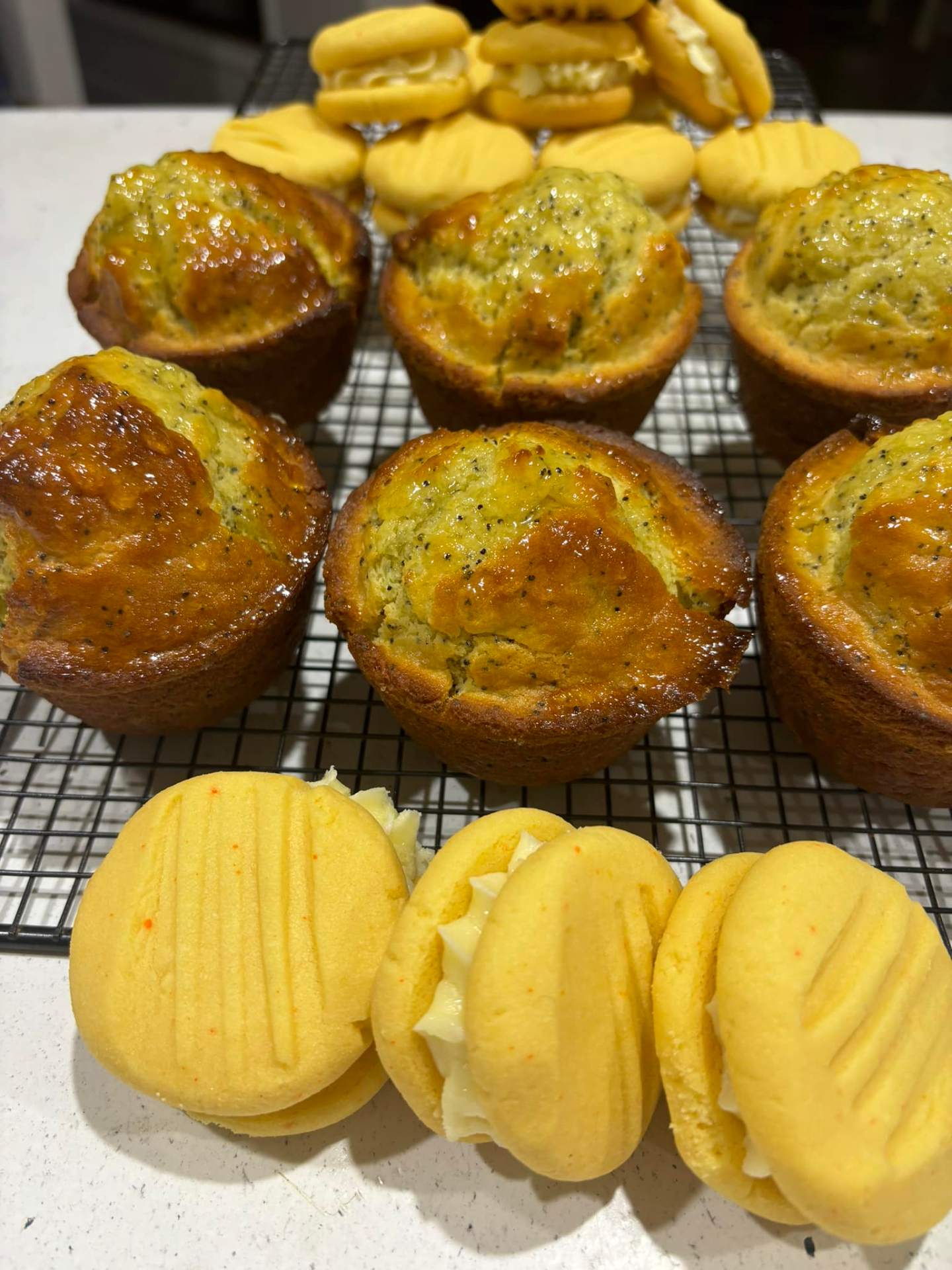 Glazed lemon poppyseed muffins on a wire rack with lemon cream melting moments